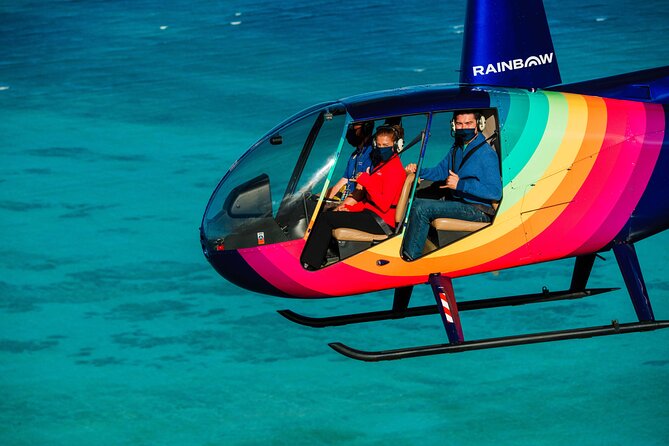 A helicopter banking over turquoise water off Oahu
